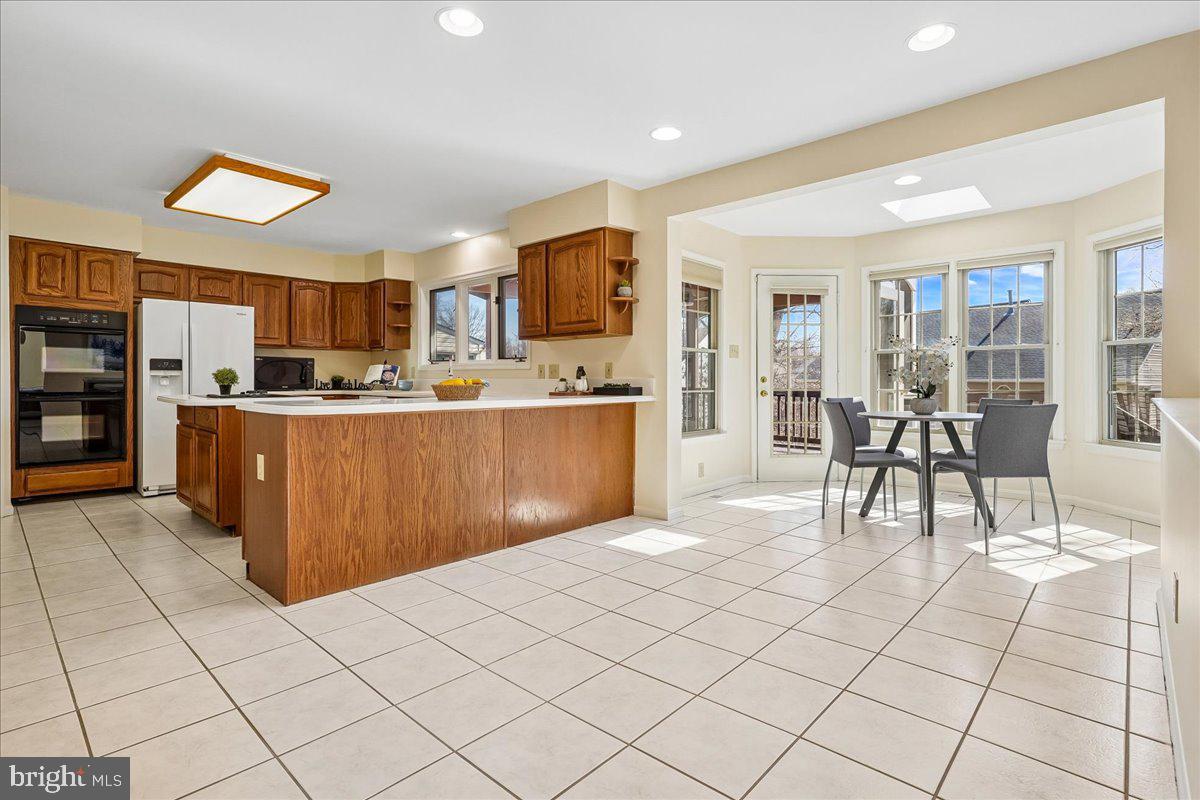 8501 Silverview Drive Lorton, VA 22079 - Photo 12 of 72 a living room with stainless steel appliances kitchen island granite countertop a table chairs and a refrigerator