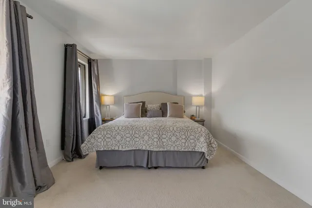 a bedroom with a bed and a refrigerator