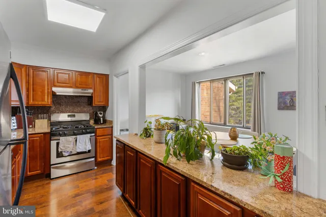 a kitchen with stainless steel appliances granite countertop a stove a sink and a refrigerator