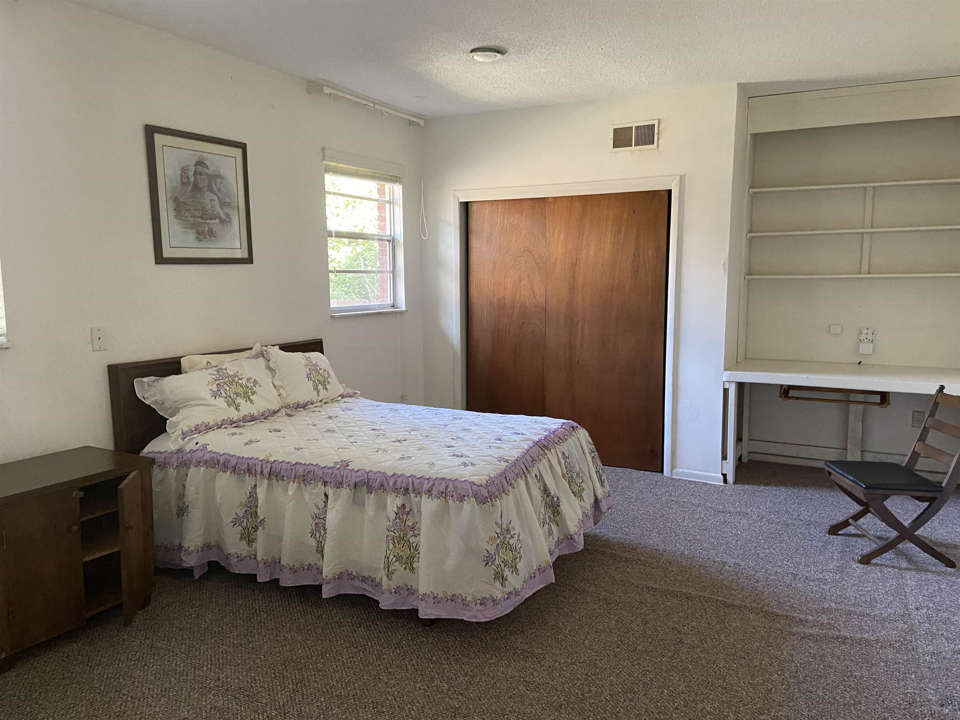 5410 Walnut Grove Road Memphis, TN 38120 - Photo 10 of 16 a bedroom with a bed and chair