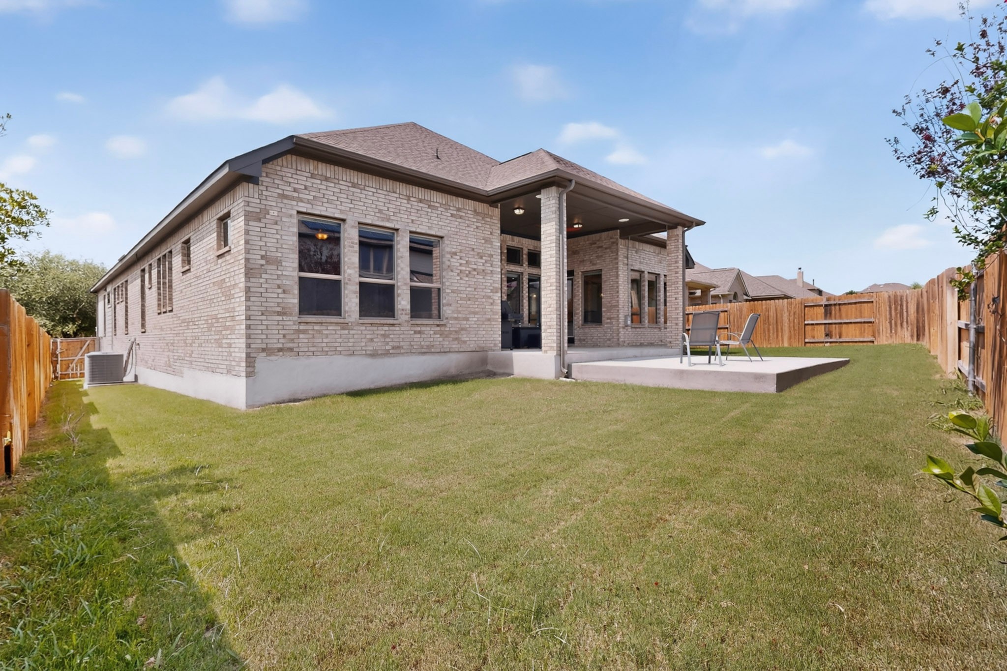 2433 La Mirada Street Leander, TX 78641 - Photo 22 of 25 Brick siding encloses this single-story residence, featuring a covered patio leading to a concrete slab for outdoor enjoyment.