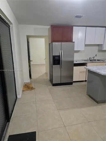 a kitchen with a refrigerator sink and cabinets
