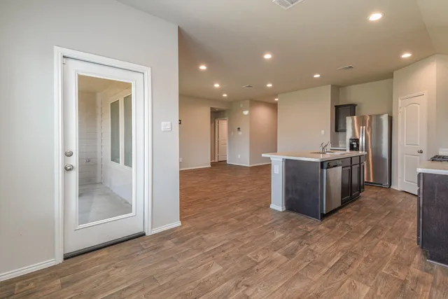 a view of a kitchen with kitchen island wooden floor center island and stainless steel appliances