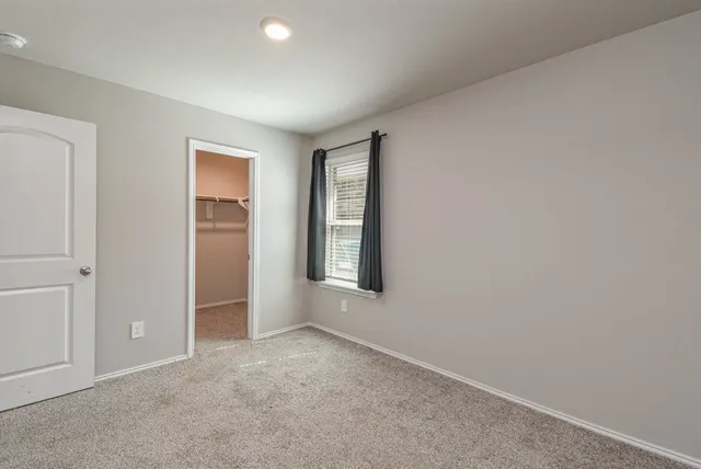 an empty room with windows and closet