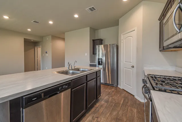 a kitchen with stainless steel appliances a sink stove and refrigerator