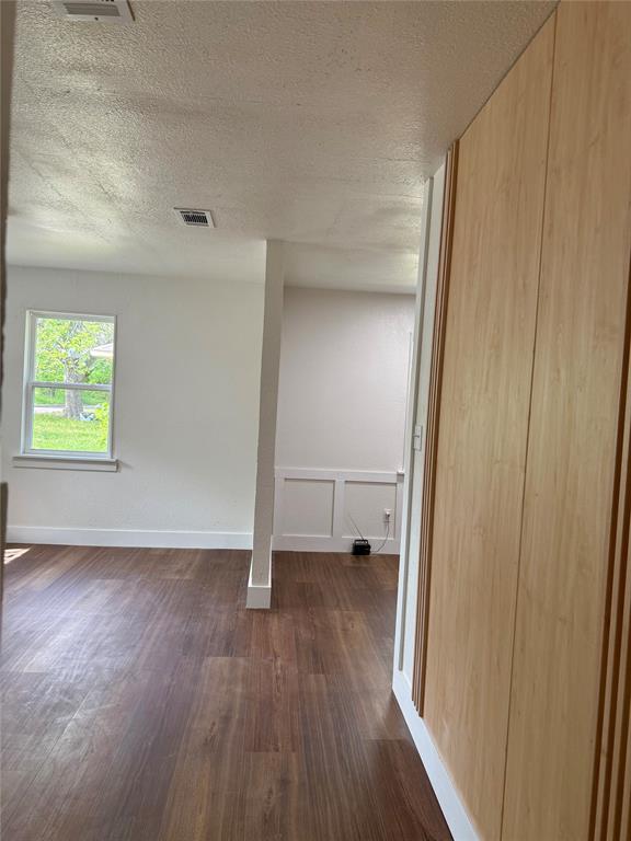 1114 Blackburn Street Commerce, TX 75428 - Photo 13 of 20 an empty room with wooden floor closet and windows