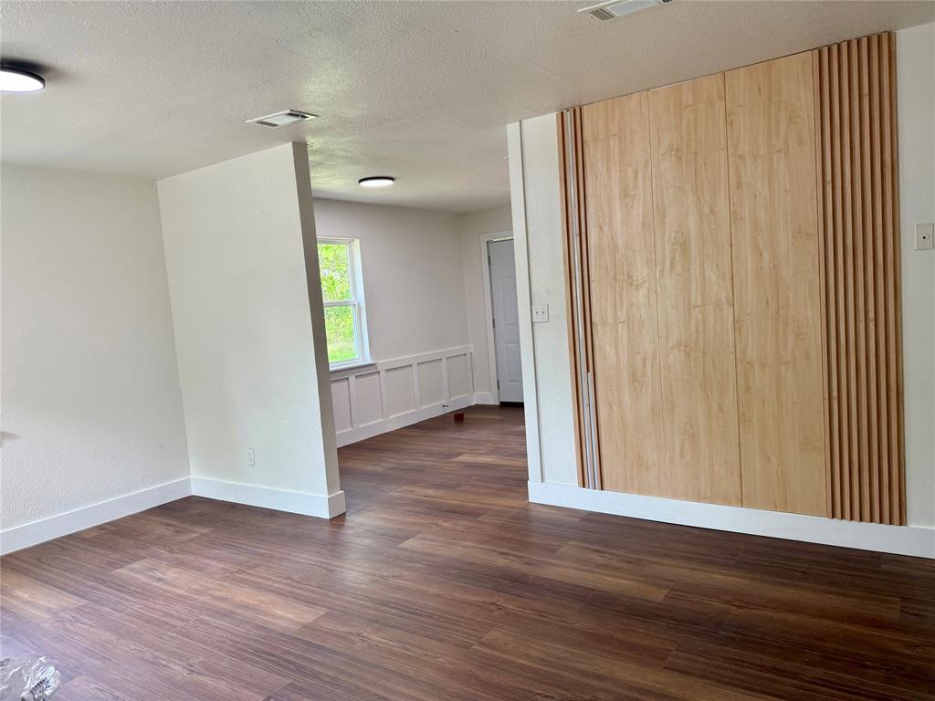 1114 Blackburn Street Commerce, TX 75428 - Photo 14 of 20 an empty room with wooden floor and a window