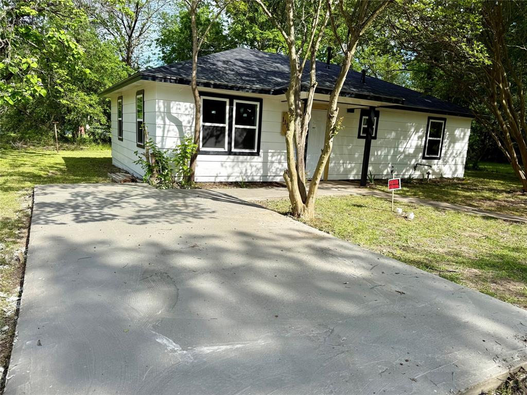 1114 Blackburn Street Commerce, TX 75428 - Photo 20 of 20 a view of a house with backyard and trees