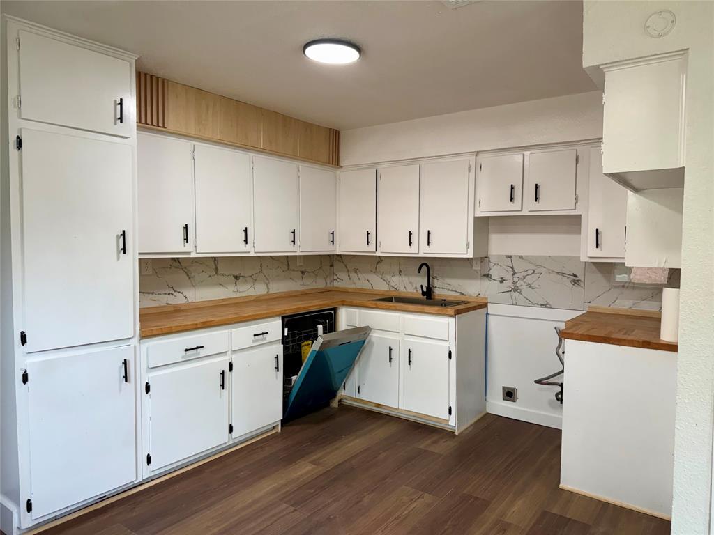 1114 Blackburn Street Commerce, TX 75428 - Photo 2 of 20 a kitchen with granite countertop white cabinets and white appliances