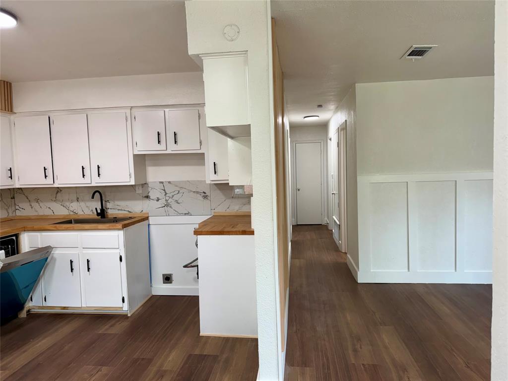 1114 Blackburn Street Commerce, TX 75428 - Photo 3 of 20 a kitchen with cabinets and wooden floor