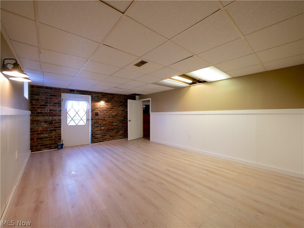57500 Hospital Road Bellaire, OH 43906 - Photo 17 of 22 Basement featuring brick wall, a drop ceiling, and light wood-type flooring