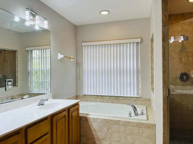 a bathroom with a tub sink and mirror