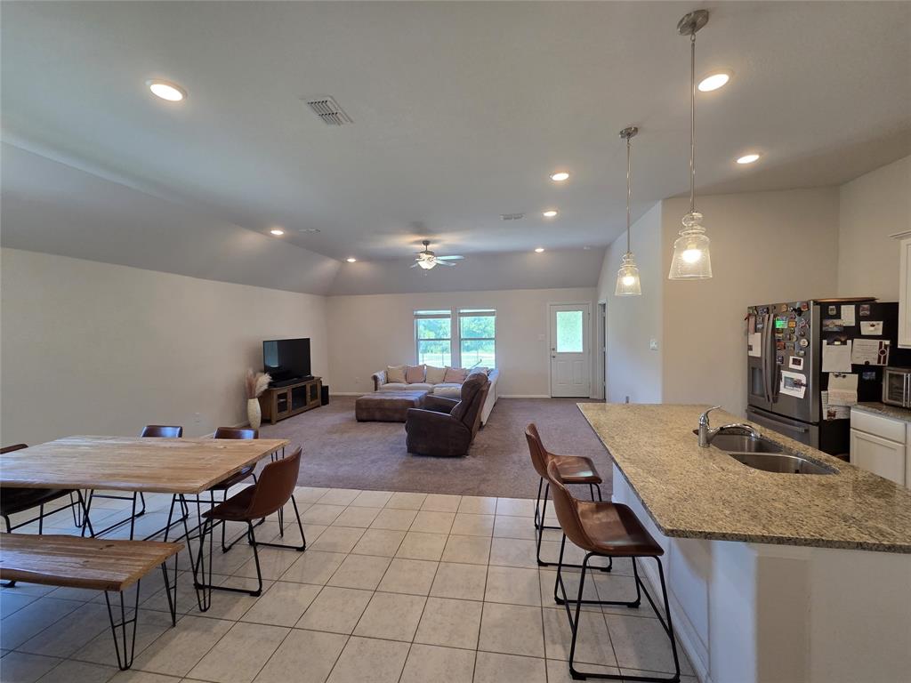 1512 Springtree Drive McKinney, TX 75071 - Photo 5 of 23 a kitchen with a dining table chairs and view of living room