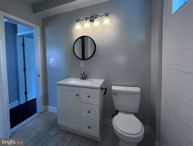 a bathroom with a toilet sink vanity and mirror