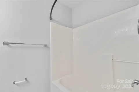 a bathroom with a white bath tub and a shower