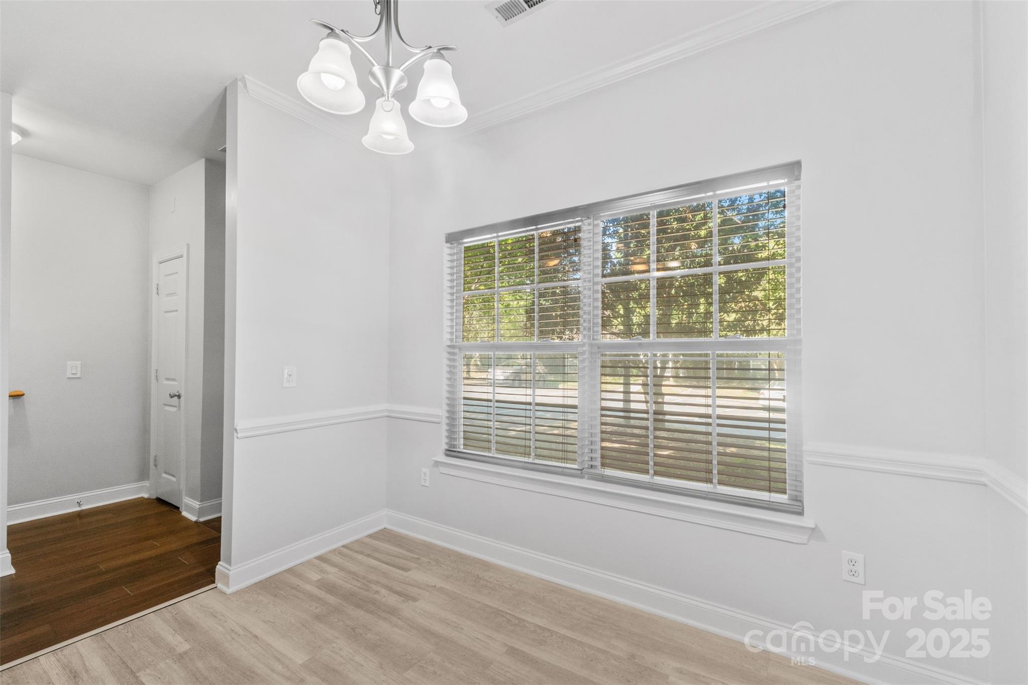 2476 Ryerson Court Charlotte, NC 28213 - Photo 4 of 30 a view of an empty room with wooden floor and a window