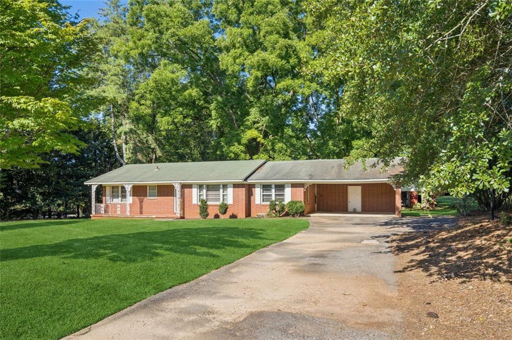 a front view of a house with a yard and trees