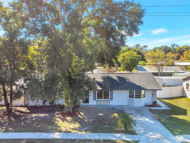 a front view of a house with a yard and mountain view