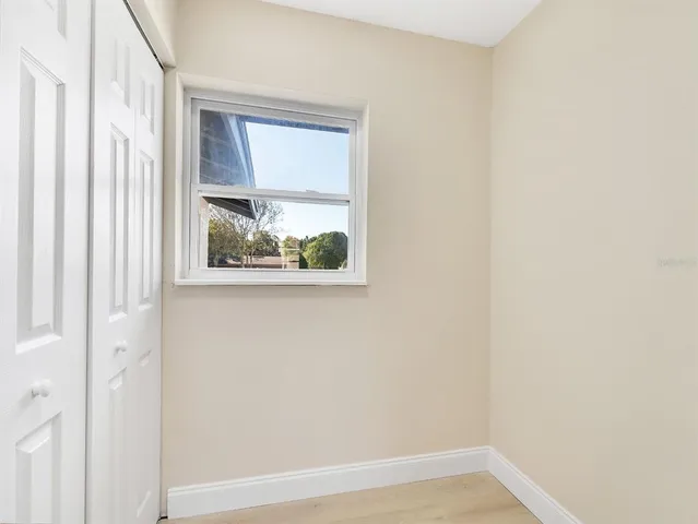 a view of a small space with wooden floor and a window