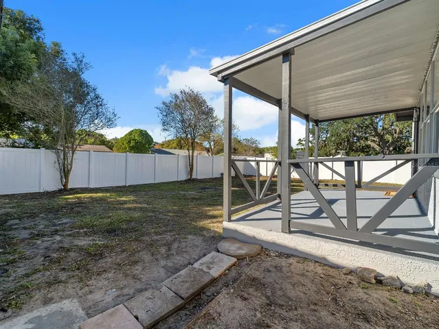 a backyard of a house with barbeque oven table and chairs
