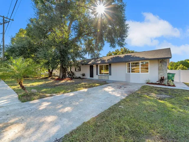 a view of a house with backyard and trees