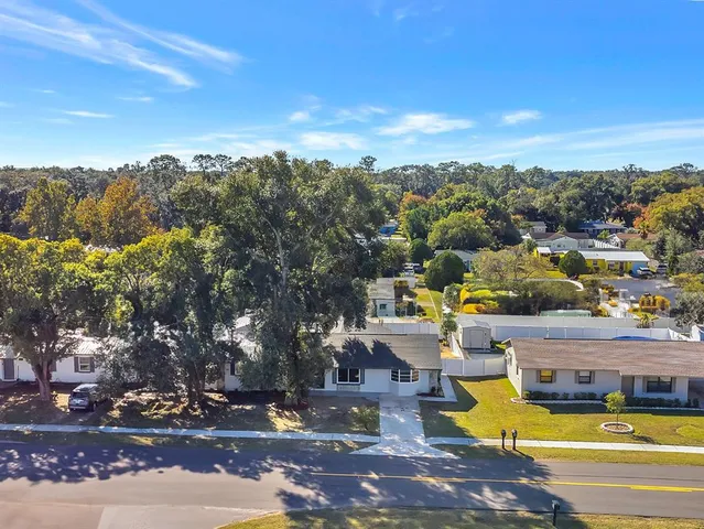 a view of a swimming pool with lawn chairs under an umbrella