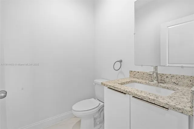 a bathroom with a granite countertop sink and vanity