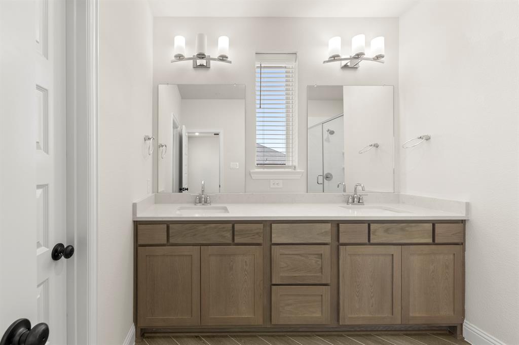 3900 Keya Drive Prosper, TX 75078 - Photo 32 of 36 a bathroom with a double vanity sink and mirror