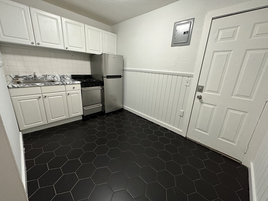 303 Hancock Street, Unit 2 Boston, MA 02125 - Photo 2 of 8 a kitchen with a sink a stove and a refrigerator