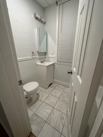 a bathroom with a sink a toilet a mirror and shower