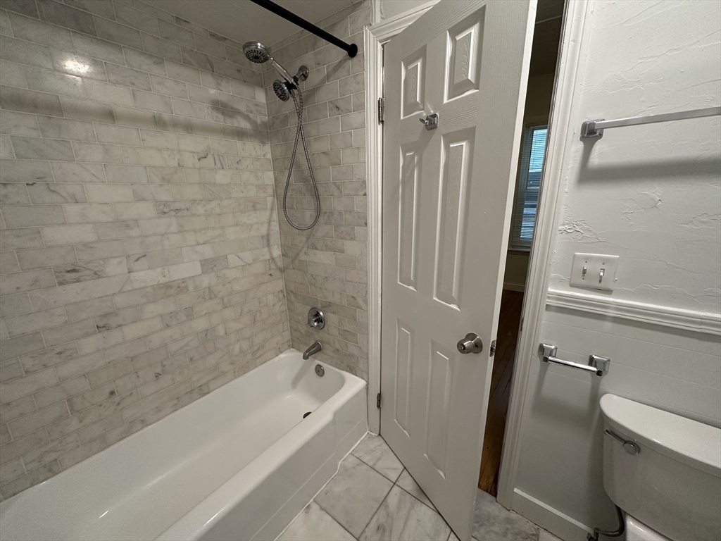 303 Hancock Street, Unit 2 Boston, MA 02125 - Photo 5 of 8 a bathroom with a tub a toilet and a shower