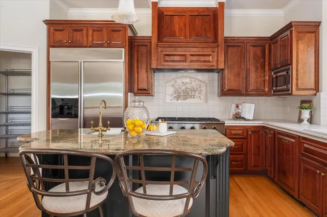 a kitchen with stainless steel appliances a stove window and cabinets
