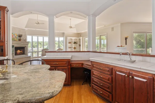 a kitchen with stainless steel appliances granite countertop a sink a stove and a wooden cabinets