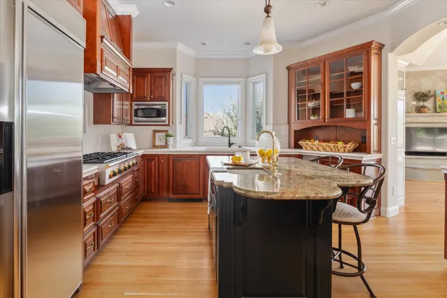 a kitchen with stainless steel appliances granite countertop a sink and a refrigerator