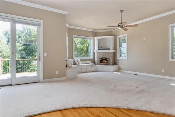 an empty room with windows and fireplace