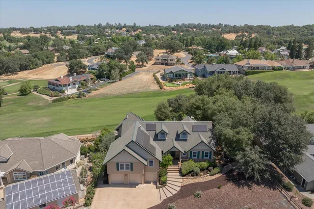 an aerial view of a house with a garden and lake view