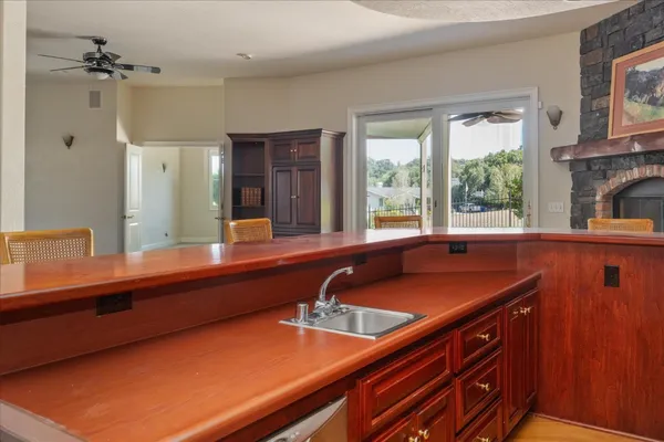 a view of an empty room with stairs and a chandelier fan