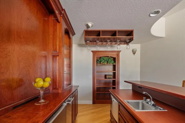 a view of an empty room with stairs and a chandelier fan