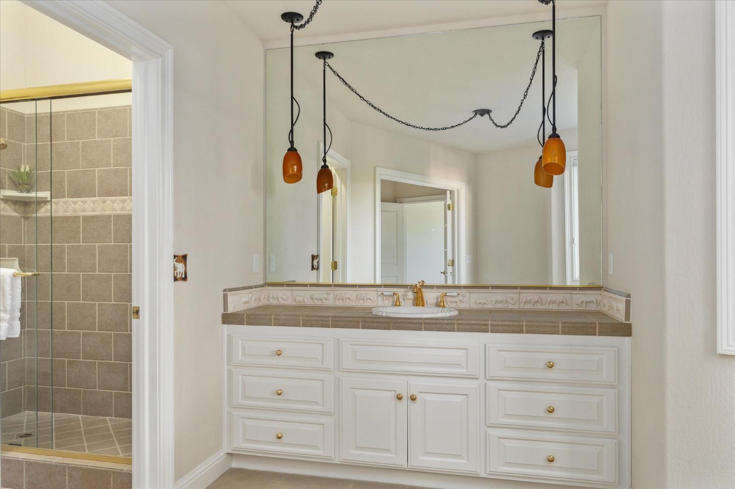643 Miwuk Way Angels Camp, CA 95222 - Photo 41 of 55 a bathroom with a granite countertop sink mirror and a shower