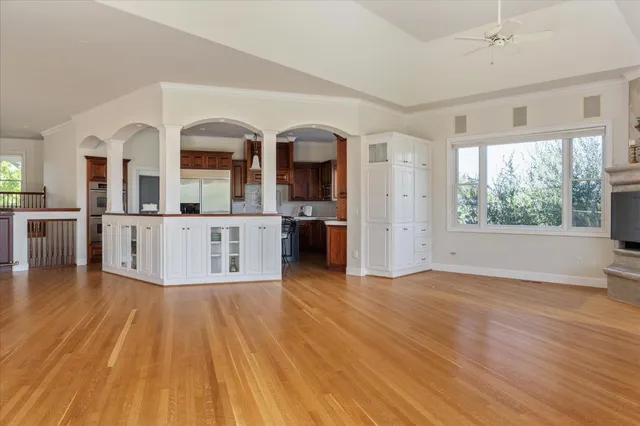 a view of a kitchen with kitchen island wooden floor and stainless steel appliances