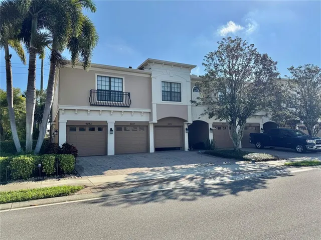 a view of a house with a yard and palm trees