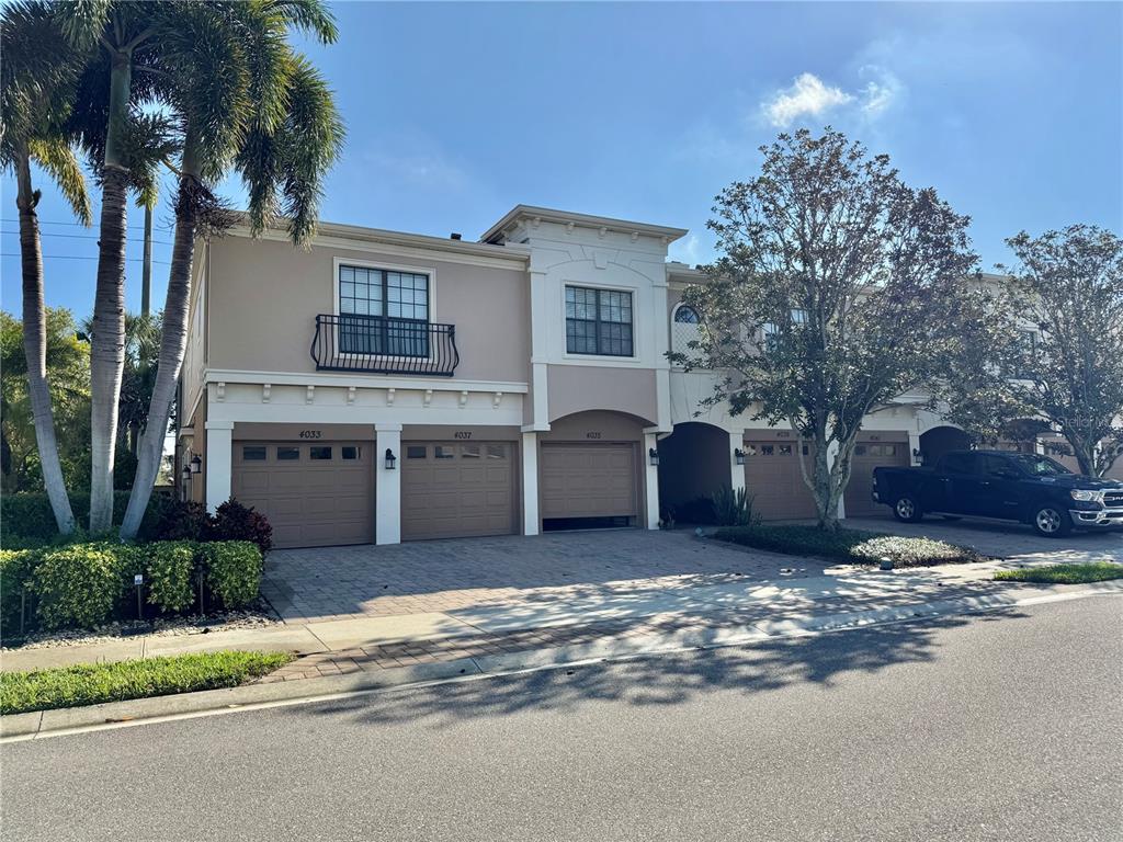 a view of a house with a yard and palm trees