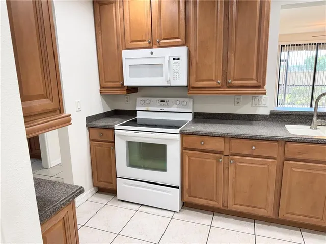 a kitchen with granite countertop white cabinets and white appliances