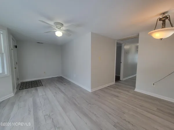 a view of an empty room with wooden floor