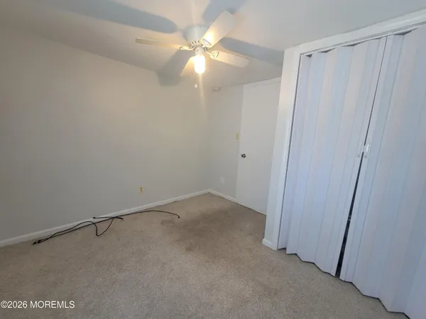 a view of a room with a ceiling fan and a window