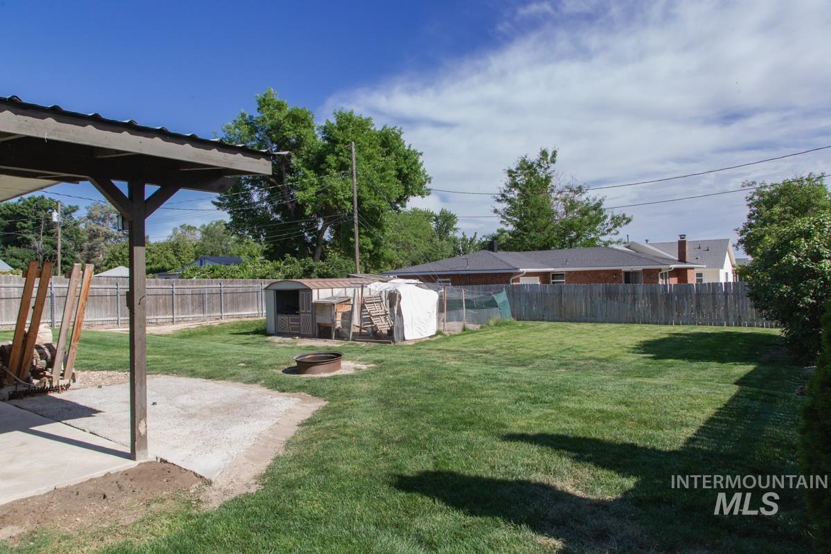 1404 Rochester Street Caldwell, ID 83605 - Photo 23 of 29 Expansive backyard featuring a covered patio, a manicured lawn, a fire pit, and a privacy fence