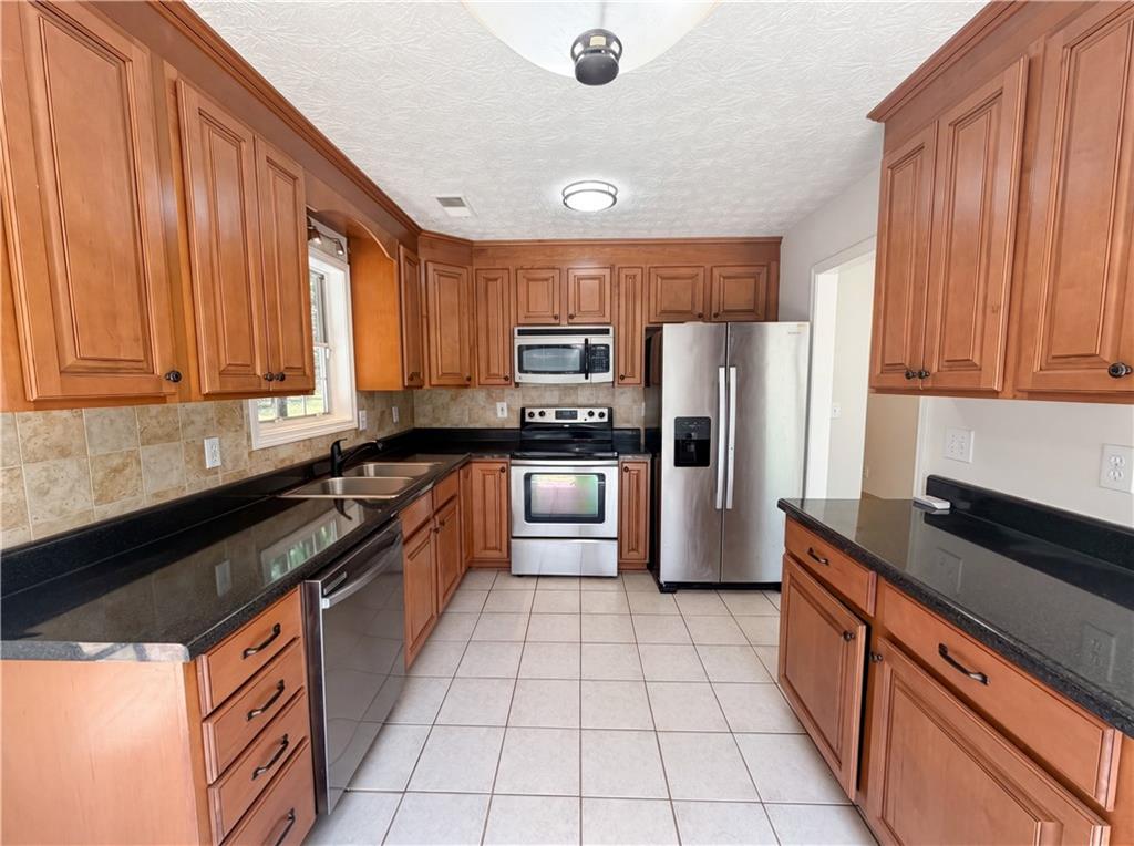 722 Ridgetop Road Bethlehem, GA 30620 - Photo 7 of 23 a kitchen with stainless steel appliances granite countertop a stove a sink dishwasher and a refrigerator