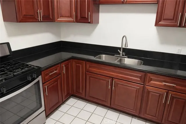 a kitchen with granite countertop wood cabinets and a stove top oven