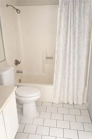 a bathroom with a toilet and a shower curtain
