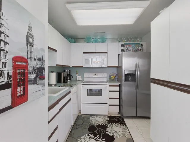 a kitchen with stainless steel appliances granite countertop a refrigerator and a stove